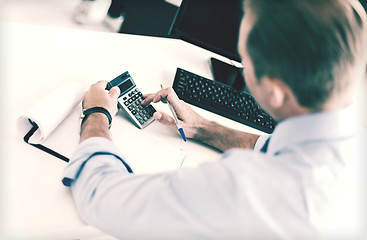 Image showing businessman with notebook and calculator