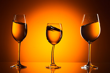 Image showing three glasses on orange background