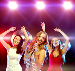 Image showing three smiling women dancing and singing karaoke