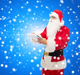 Image showing man in costume of santa claus with notepad