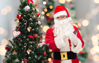 Image showing santa claus with smartphone and christmas tree