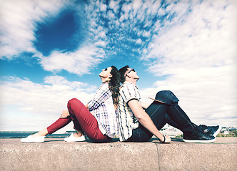 Image showing teenagers sitting back to back