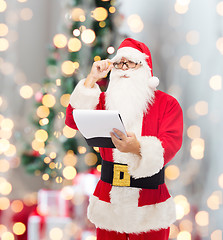 Image showing man in costume of santa claus with notepad