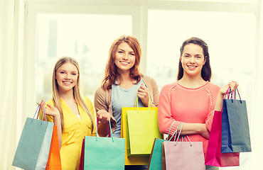 Image showing smiling teenage girls with many shopping bags