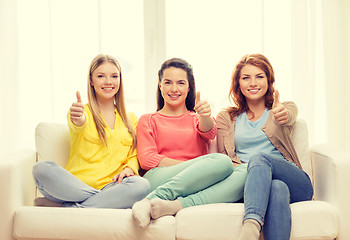 Image showing three girlfriends showing thumbs up at home