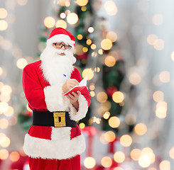 Image showing man in costume of santa claus with notepad