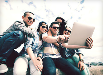 Image showing group of teenagers looking at tablet pc