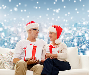 Image showing happy senior couple in santa hats with gift boxes