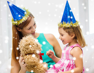 Image showing mother and daughter in party hats with toy