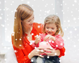 Image showing mother and daughter with piggy bank