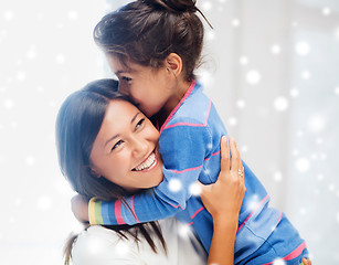 Image showing smiling little girl and mother hugging indoors