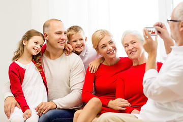 Image showing smiling family with camera at home