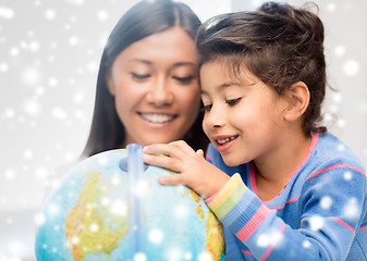 Image showing mother and daughter with globe indoors