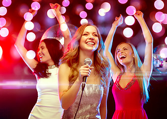 Image showing three smiling women dancing and singing karaoke