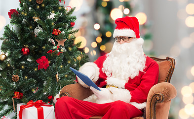 Image showing man in costume of santa claus with tablet pc