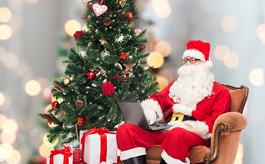 Image showing man in costume of santa claus with laptop