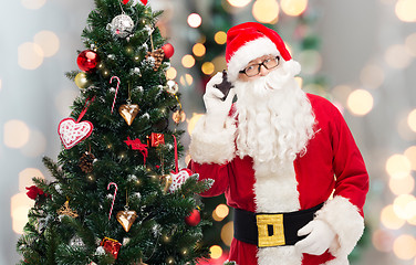 Image showing santa claus with smartphone and christmas tree