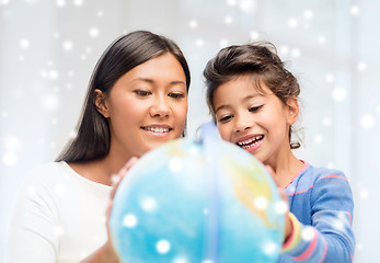 Image showing mother and daughter with globe indoors