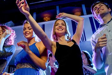 Image showing smiling friends dancing in club