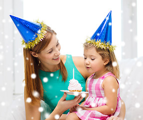 Image showing mother and daughter in party hats with cake