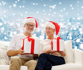 Image showing happy senior couple in santa hats with gift boxes