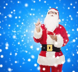 Image showing man in costume of santa claus with notepad