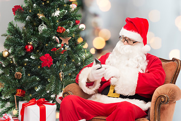 Image showing santa claus with smartphone and christmas tree