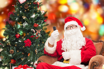 Image showing santa claus with smartphone and christmas tree