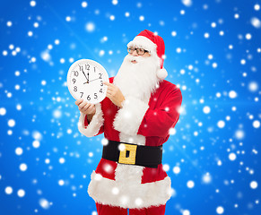 Image showing man in costume of santa claus with clock