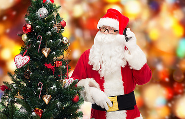 Image showing santa claus with smartphone and christmas tree