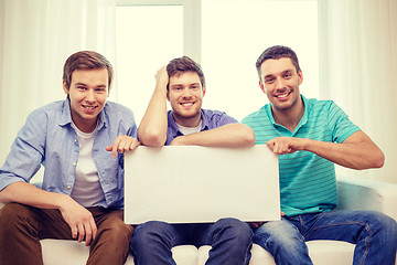 Image showing smiling male friends holding white blank board