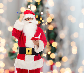 Image showing man in costume of santa claus with notepad