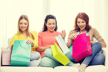 Image showing smiling teenage girls with many shopping bags