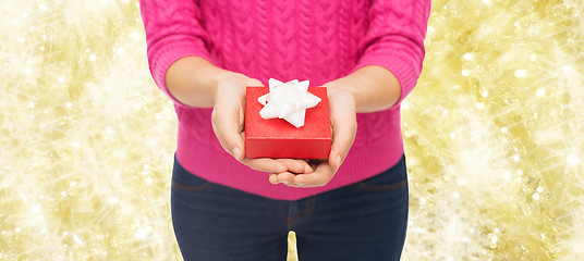 Image showing close up of woman in pink sweater holding gift box