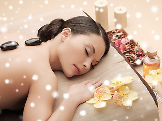 Image showing woman in spa salon with hot stones