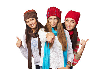 Image showing Three girls showing approving gestures pointing at camera