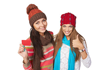 Image showing Two winter girls showing blank card