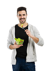 Image showing Young man eating a salad