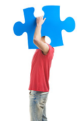 Image showing Young man holding a puzzle piece