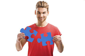 Image showing Young man holding a puzzle piece