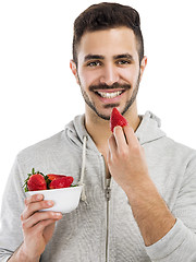 Image showing Happy young eating a strawberry