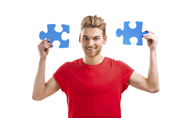 Image showing Young man holding a puzzle piece