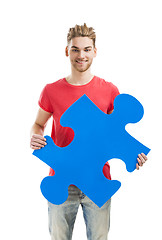 Image showing Young man holding a puzzle piece