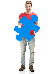 Image showing Young man holding a puzzle piece