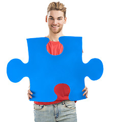 Image showing Young man holding a puzzle piece