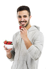 Image showing Happy young eating a strawberry