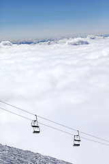 Image showing Ski slope, chair-lift and mountains under clouds