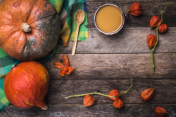Image showing Rustic style pumpkins, soup and ground cherry branches on wood