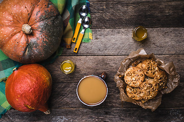 Image showing Pumpkins, soup, honey and cookies with nuts on wood