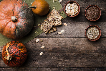 Image showing Rustic style pumpkins with seeds and cookies on wooden table